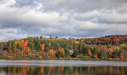 Fall colours along the Gatineau river reflected in water, Quebec, Canada