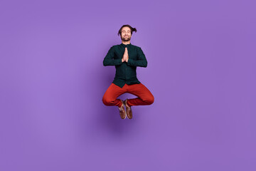 Fototapeta na wymiar Photo of dreamy handsome young guy dressed smart casual clothes jumping arms together practicing yoga isolated violet color background