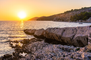 Beautiufl sunset on the rocky beach of Hvar Island, Croatia - obrazy, fototapety, plakaty