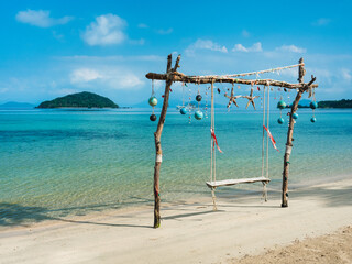 Fototapeta na wymiar Scenic white sand beach tropical island with relax wooden swing and turquoise sea against blue sky in summer. Koh Mak Island, Trat, Thailand.