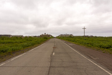 A deserted road leading to the ghost settlement of Sovetsky. Abandoned town. Russia.