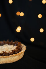Coconut and dulce de leche cake with a black background with bokeh lights