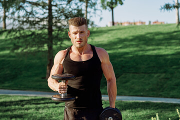Fototapeta premium pumped up sports Vykhino in the park with dumbbell workout