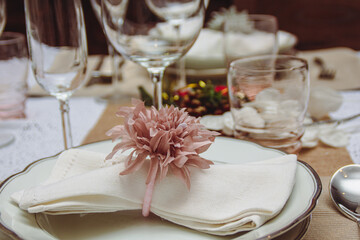 Close-up napkin on dish glass and two different cups on shiny tablecloth in Christmas season. Christmas decoration for dining tables