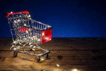 Shopping concept image with a shopping cart and christmas led lights
