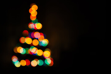 Christmas tree multicolored bokeh on dark background. Defocused multi colored lights. New Year,...