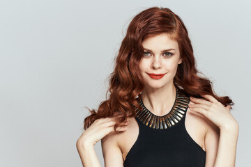 Fototapeta premium red-haired woman in black dress red lips glamor posing