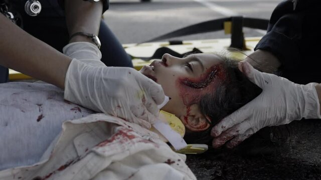 Paramedics helping injured indian girl after car accident