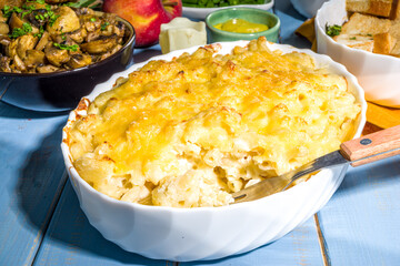 Thanksgiving dinner table with new traditional thanksgiving food - chicken, mashed sweet potatoes,...