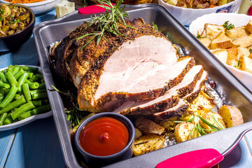 Thanksgiving dinner table with new traditional thanksgiving food - chicken, mashed sweet potatoes, green beans, pecan pie, baked ham pork, mac and cheese, stuffing, modern hard sunny light flatlay