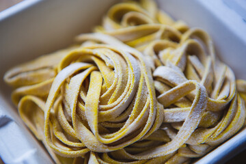 Frozen tagliatelle pasta in container. Uncooked Italian noodles for cooking