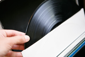 Dj holding vinyl record disc with music for turn table player. Listen to the musical tracks in hi...