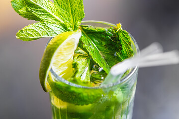 Refreshing mojito cocktail with lime and mint leaves. Fresh green alcoholic drink with ice in glass