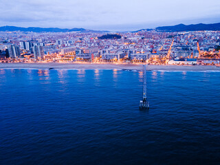 Beautiful shot of a long pier and observation deck on the beach in Badalona at night