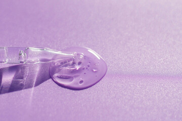 Pipette close-up on a purple background in soft focus. Beautiful shadow in the sunlight. Skincare products , natural cosmetic. Beauty concept for face and body care