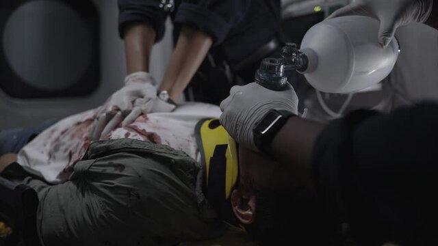 Team of paramedics doing heart massage for patient