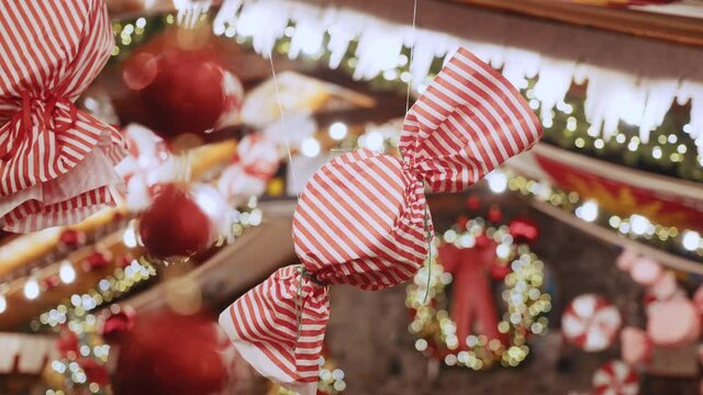 A large Christmas decoration in the form of candy hangs in a beautiful house or shop. Xmas ball and decoration candies on new year tree, christmas mood, merry christmas and happy new year.