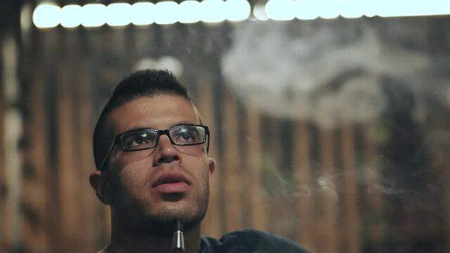 Arabic jordanian young man smokes a hookah.