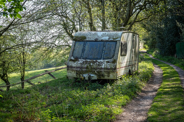 Abandoned touring caravan on the roadside verge of a farm track, Boundary, Staffordshire, England,...