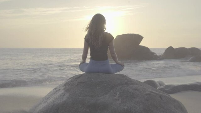 Meditating on a rock at sunset