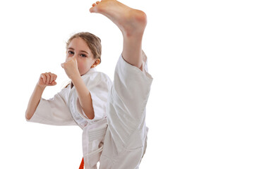 Close-up portrait of little girl, young karate training alone isolated over white background....