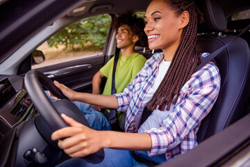 Profile side view portrait of handsome beautiful cheerful couple driving car traveling way road...