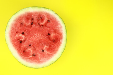 half of fresh watermelon on a bright yellow background
