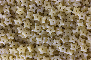 Close-up of durum wheat star shaped pasta with hole, baby food and first course concept. Stelline prepares quickly.