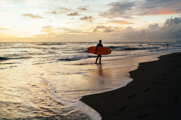 Fototapeta na wymiar Unrecognizable traveler with surfboard walking near sea