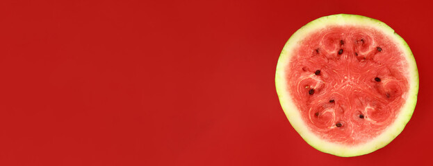 half of fresh watermelon on a red background. Horizontal banner. Copy space for text