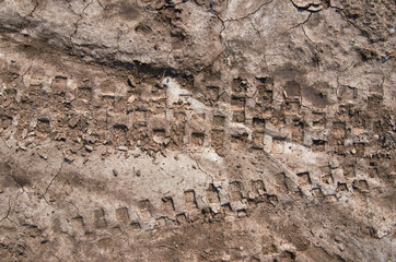 Motorcycle tire tracks on a muddy trail. Tire tracks on a wet muddy road, abstract background, texture material. Tire track on clay, sand driving, off road