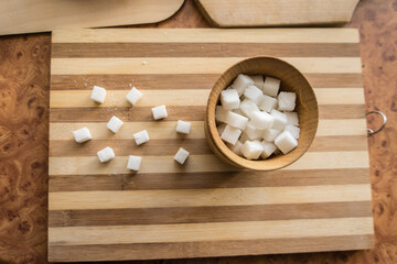 Obraz na płótnie Canvas Sugar and refined sugar are poured into the sugar bowl on the table.