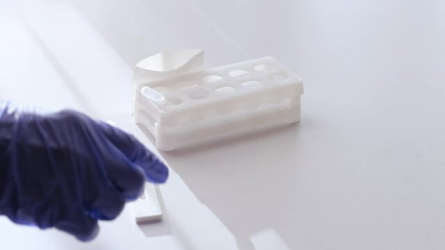 unfocused doctor in blue gloves holding test kit, negative result by using rapid fast test device for COVID-19,  laboratory equipment. S