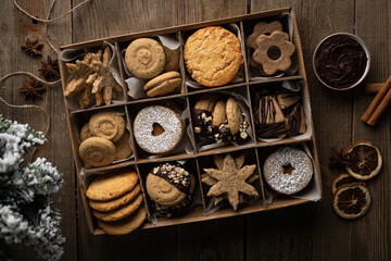 Obraz na płótnie Canvas Boîte de biscuits sablés de Noël assortis sur une table avec sapin et décorations de Noël