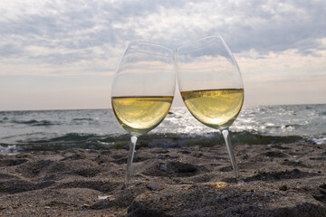 Romantic glass of white wine, on the sea beach. Wine tasting and relaxation at the resort
