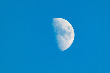 Crescent moon. The crescent moon during the day next to the completely clear and blue sky. Snow...
