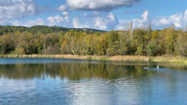 Two canoe pirogue crossing a calm lake with turquoise water in Banyoles Girona Costa Brava of Spain