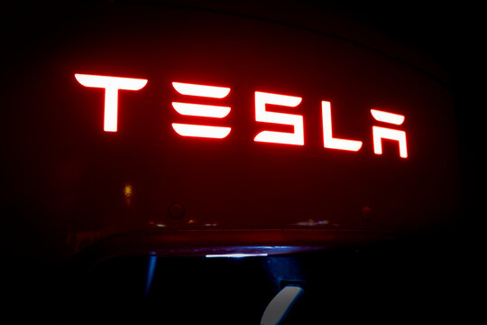 Modena, Italy - November 12, 2021: Tesla logo on supercharger station at night.