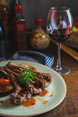 Fried ribs with a glass of red wine on a table in a restaurant close-up