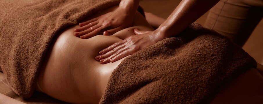 Cellulite removal procedures. Female hands massage the girl's abdomen. Taking care of your body in a saved salon