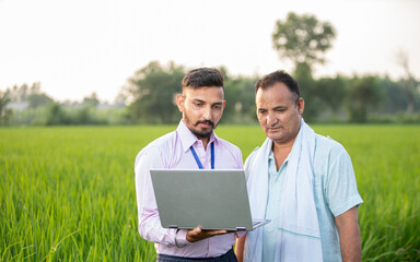 indian Agronomist with farmer explaining about the crop factors and policies 