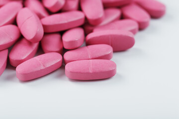 Obraz na płótnie Canvas Pink pills with multivitamins on a white background.