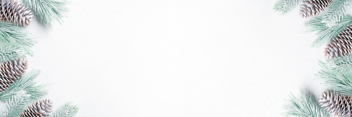 White Christmas banner with frosted Christmas tree branches and fir cones