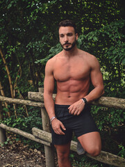 Handsome Muscular Shirtless Hunk Man Outdoor in Country Leaning Against Fence