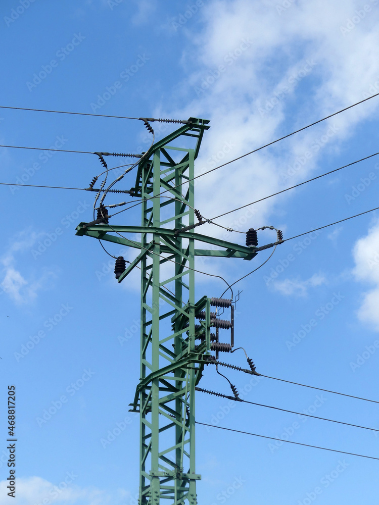 Sticker vertical shot of an electricity pylon with lines on a blue sky background