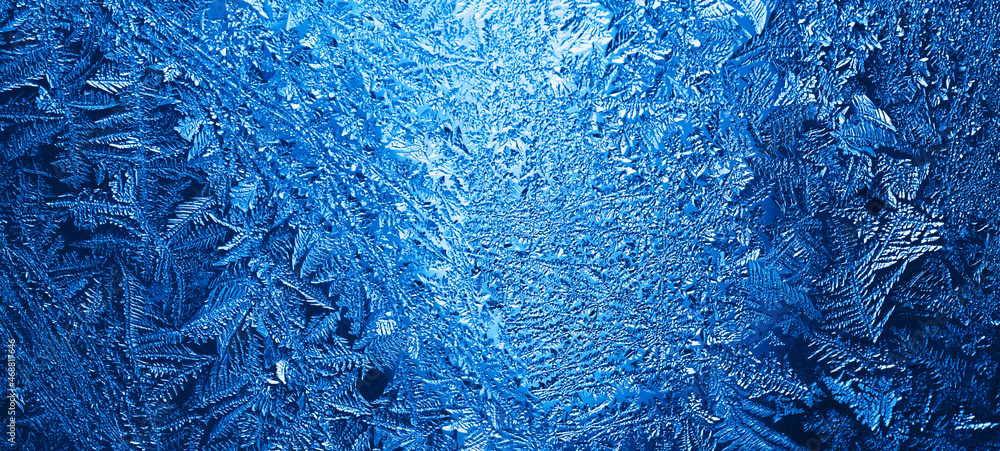 Sticker winter frosty blue patterns on the glass. icy, frosty pattern on the window glass. background for ch