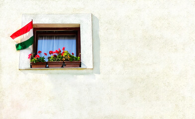 Hungarian flag in the window of the house. National Independence Day. Travel concept.