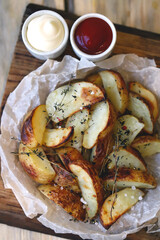Soft focus. Appetizing homemade rustic potato wedges with sauces.