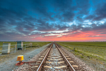 Railroad to horizon under fantastic sunset sky