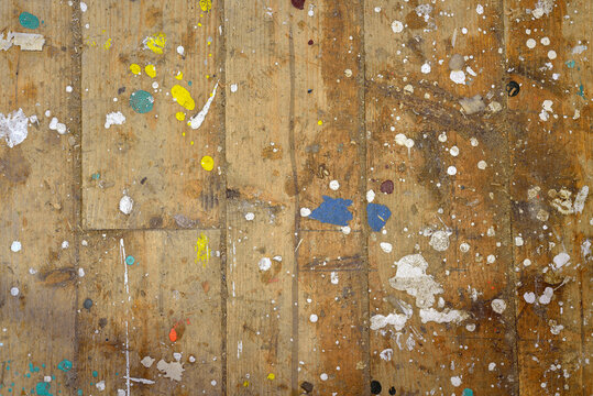 Colorful boat paint droplets on a pine wood plank woodshed floor